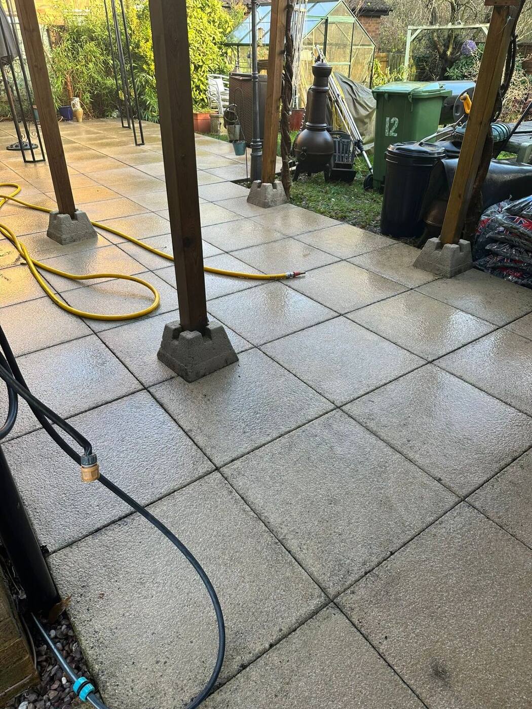 Clean patio area beneath pergola after professional pressure washing