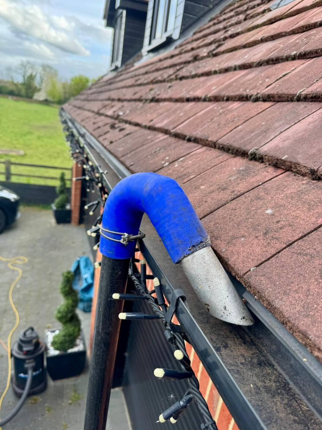 Gutter vacuum pole reaching high-level gutters on a Milton Keynes home with dormer windows