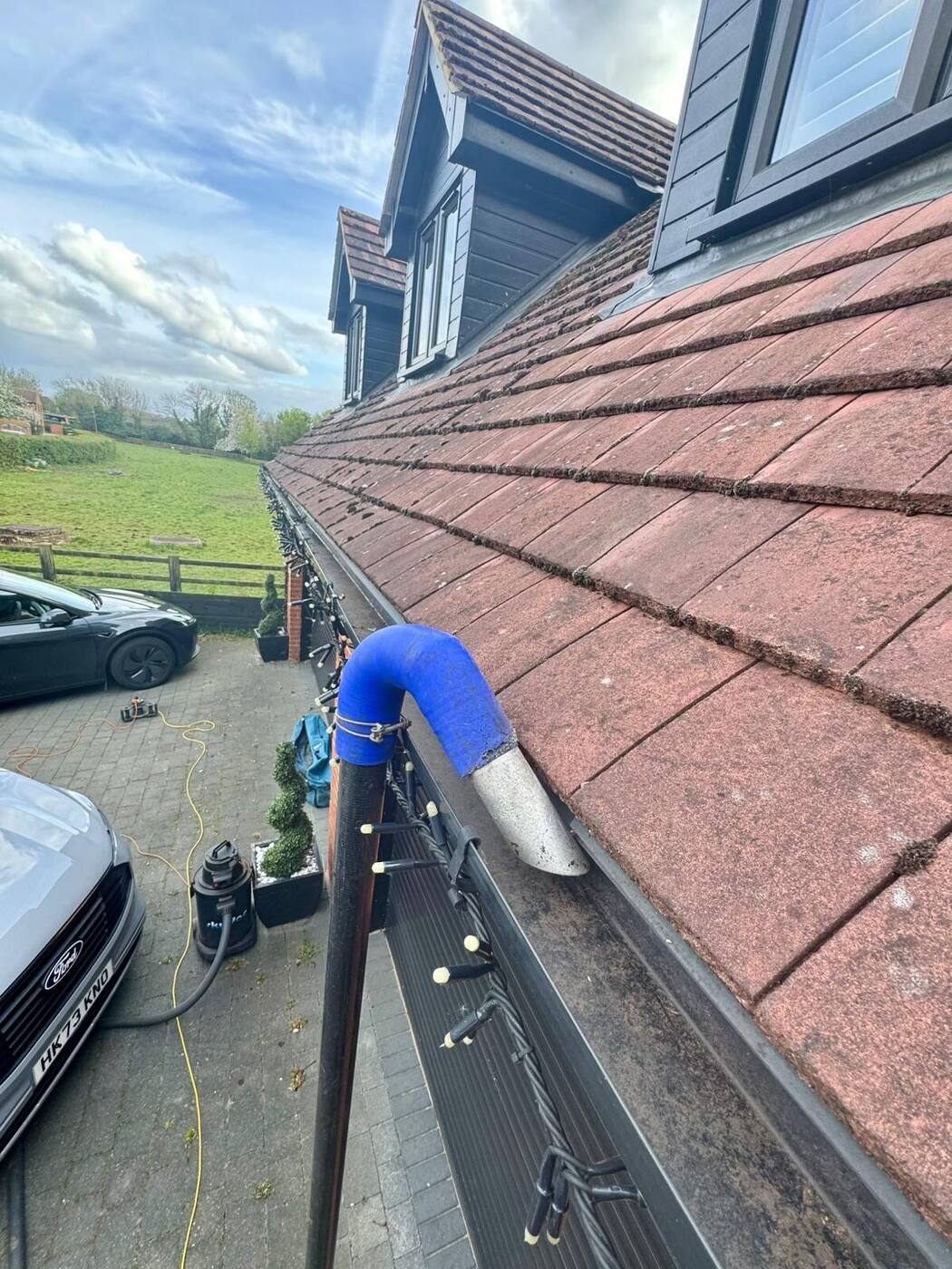 Wide view of gutter vacuum system clearing upper-storey gutters on a Milton Keynes property