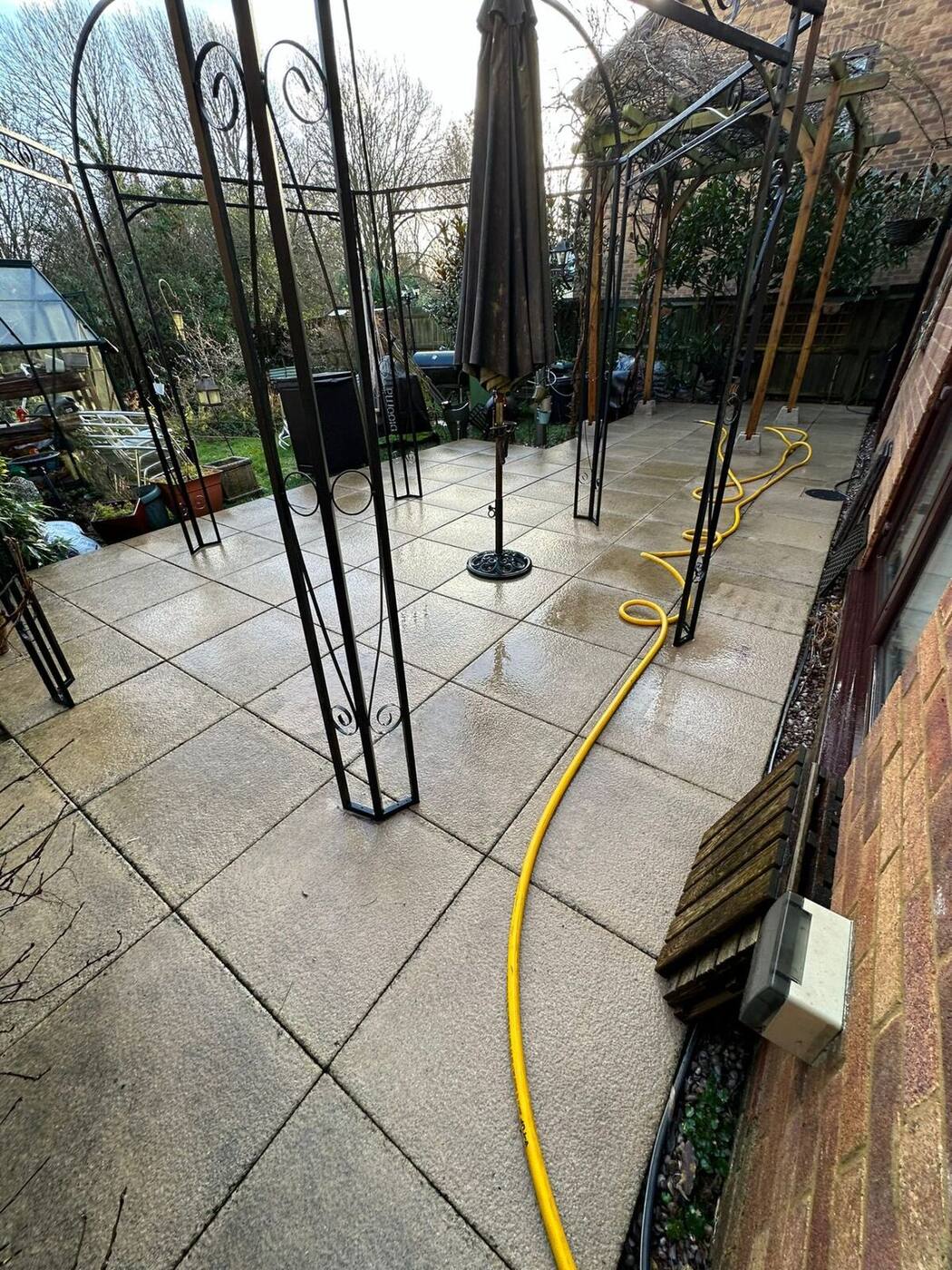 Clean bright patio tiles after professional pressure washing under garden gazebo